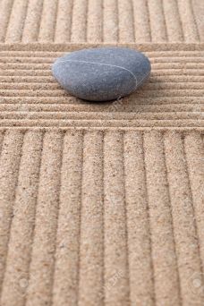 18367373-un-caillou-sur-un-jardin-zen-sable-ratiss-la-recherche-le-long-des-sillons-banque-dimages
